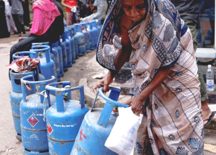 Seorang wanita  memindahkan tabung gas saat antre membeli gas di sebuah distributor di Colombo, Sri Lanka, pada 1 Juni  2022, di tengah krisis ekonomi yang melanda Sri Lanka. ** ant/rtr