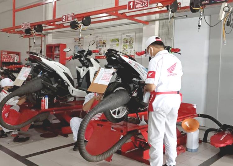 Mekanik AHASS yang terstandarisasi melakukan pengecekan sepeda motor konsumen.(ist)
