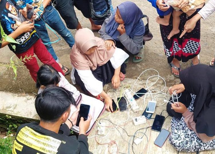 Warga mengisi baterai ponsel mereka dari genset yang disediakan tim teknisi XL Axiata di Desa Cijedil, Kecamatan Cugenang, Cianjur. (ist)