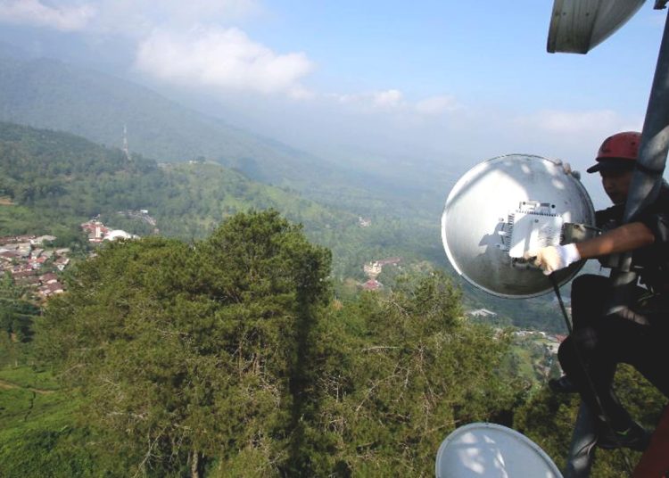 Teknisi melakukan pemeliharaan rutin di atas menara BTS milik XL Axiata.(ist)
