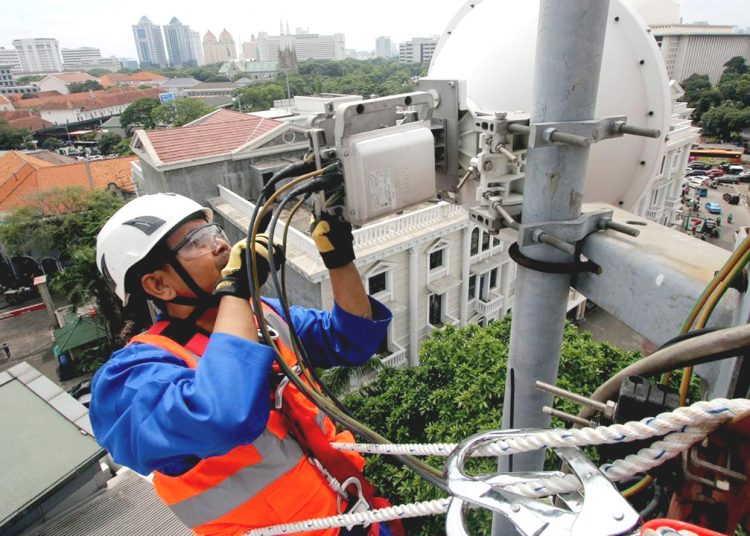 Teknisi melakukan pemeliharaan rutin di atas menara BTS milik XL Axiata.(ist)