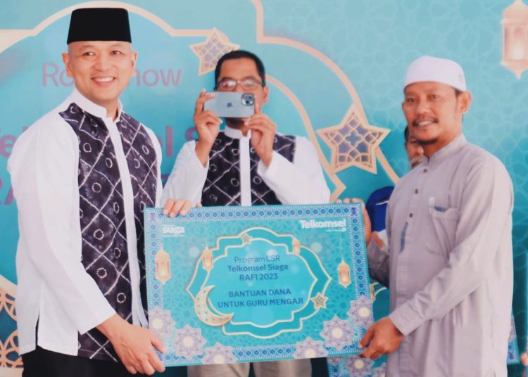 Komisaris Telkomsel Yose Rizal (kiri) secara simbolis menyerahkan bantuan dana kepada guru mengaji pada momen Roadshow Telkomsel Siaga Ramadan dan Idulfitri di Banjarmasin Kalimantan Selatan, Senin.(ist)