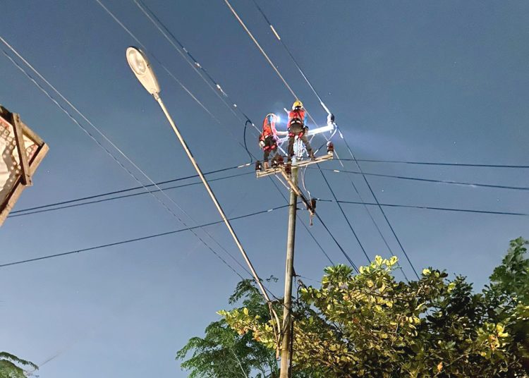 Petugas PLN melakukan perbaikan jaringan yang putus akibat kawat layangan.(ist)