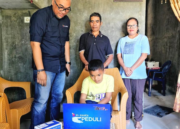 Caesar Archangels Hendrik Meo Tnunay atau Nono mencoba laptop hadiah dari XL Axiata disaksikan oleh Head Of Sales XL Axiata area NTT, Boni Hendra (kiri) bersama kedua orang tuanya di Kupang.(ist)