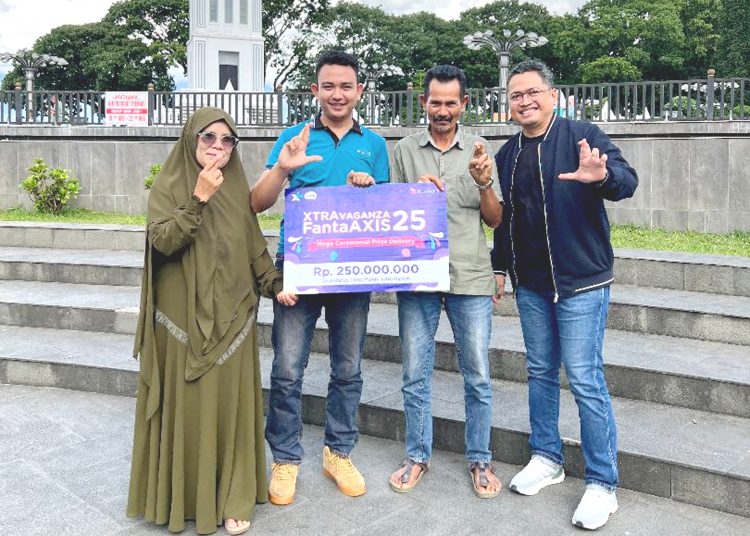 Head of Sales XL Axiata area Sumbar – Jambi, Trisna Gunawan (paling kanan) menyerahkan hadiah pemenang kuis Xtravaganza/FantAXIS sebesar Rp 250 juta kepada Muhammad Suci (ke dua dari kiri) bersama keluarga di depan Jam Gadang, Bukittinggi, Selasa.(ist)