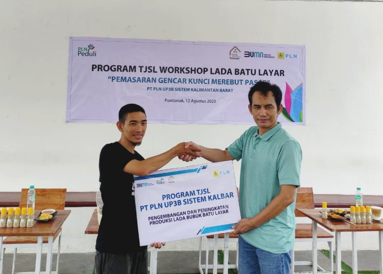 Manager PLN UP3B Sistem Kalbar Sudarto menyerahkan bantuan kepada Ketua Koperasi Srikandi Jaya Sambas, Juliansyah.(ist)
