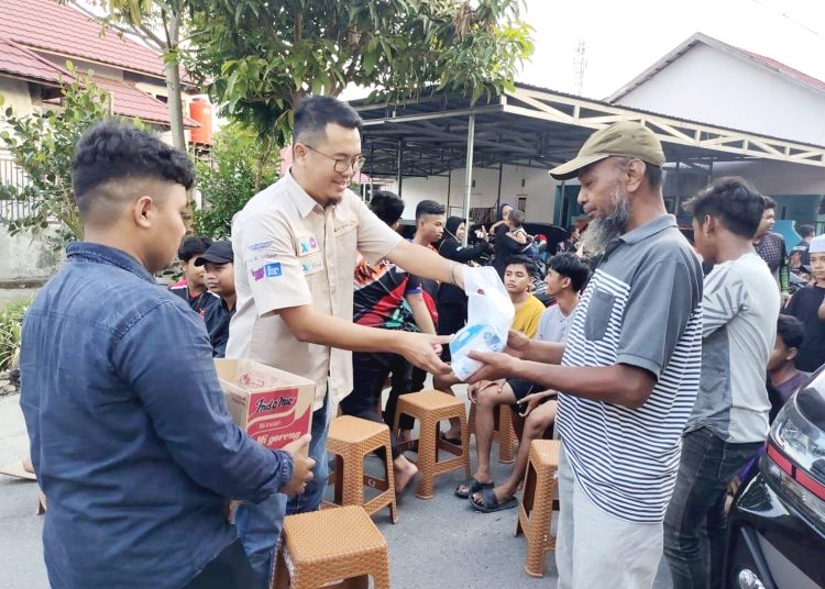 Head of Sales XL Axiata area Kalimantan Selatan dan Kalimantan Tengah, Hurry Amar Sidqi (dua dari kiri) menyerahkan bantuan kepada salah satu warga yang terkena dampak kabut asap di Kelurahan Sungai Andai, Kota Banjarmasin, Kalimantan Selatan, Rabu.(ist)