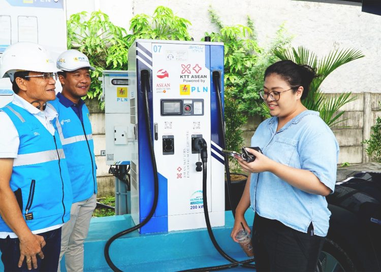 Plt. Direktur Utama PLN Haleyora Power, Isral (kiri) ketika menyapa seorang pelanggan yang sedang melakukan pengisian daya kendaraan listriknya di rest area KM 6 Jakarta-Cikampek.(ist)