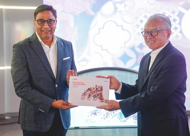 President Director & CEO IOH Vikram Sinha saat memberikan Buku Empowering Indonesia Report 2024 kepada Komisaris Utama IOH Halim Alamsyah di Jakarta, Senin.(ist)