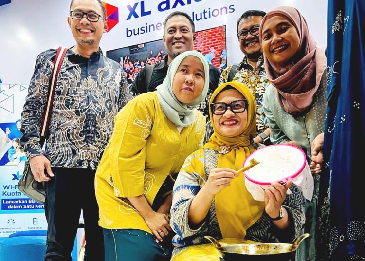 Presiden Direktur & CEO XL Axiata, Dian Siswarini (duduk) mencoba membatik di booth XL Axiata di arena Pameran HUT ke-44 Dekranas di Surakarta, Sabtu.(ist)