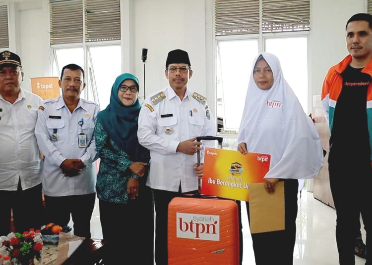 PJ Bupati Mempawah, Ismail (tengah) dan Direktur BTPN Syariah, Fachmy Achmad (kanan) bersama ibu-ibu kumpulan BTPN Syariah yang mendapatkan reward umrah gratis.(ist)