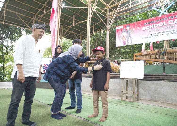 Manager Corporate Social Responsibility AHM Catur Sri Wulandari (Tengah) dan Direktur Utama PT Saung Angklung Udjo Taufik Hidayat Udjo (Kiri) melakukan penyematan pin angklung kepada peserta sebagai tanda dimulainya kegiatan School Camp 2025. (ist)