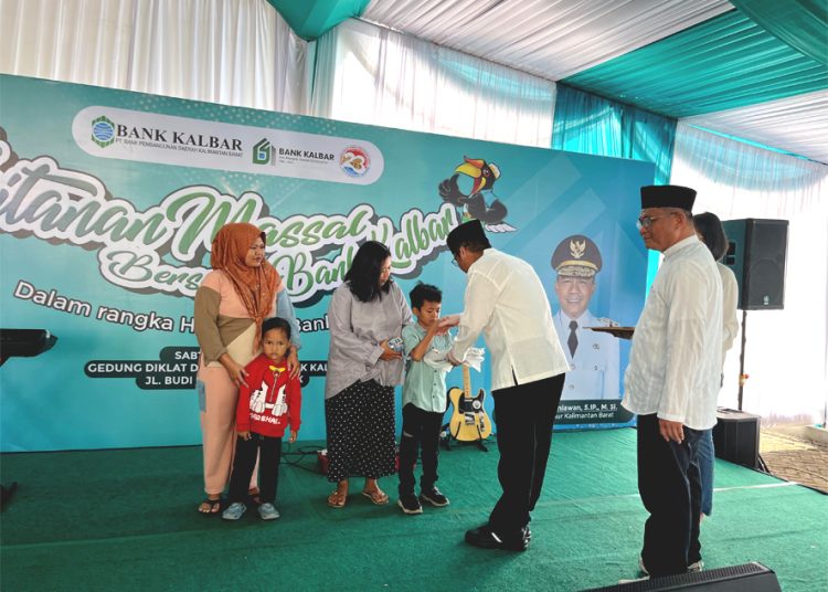 Direktur Pemasaran Bank Kalbar, Yuse Chaidi Amzar memberikan hadiah kepada anak-anak yang melakukan khitanan massal. (dok)