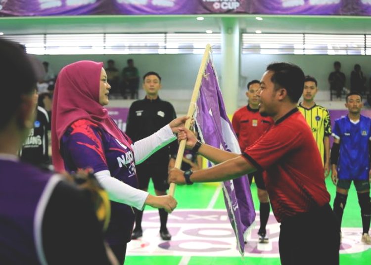 Group Head Region Jabo XLSMART, Rd. Sofia Purbayanti (kiri) menyerahkan Bendera AXIS kepada wasit Utama atau Referee dalam preliminary Bekasi AXIS Nation Cup 2025.(ist)